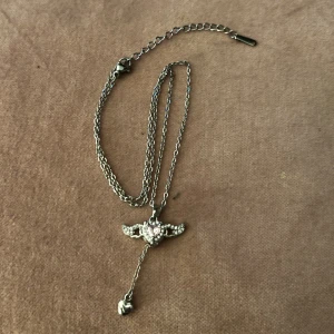 Halsband - Halsband med hjärta. Om man drar i kedjan längst ner så rör sig vingarna på hjärtat