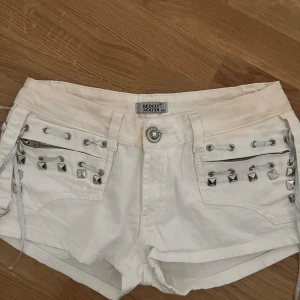 Vita shorts med nitar från Bebe - Säljer ett par supersnygga vita shorts med nitar. Märket heter Redox.