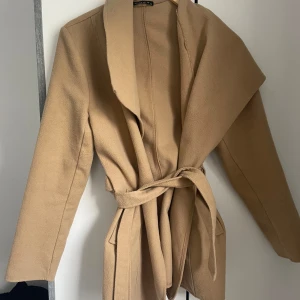 Kappa - Tunnare kappa i färgen beige. Storlek 38. Använt ett par gånger men är fortfarande i mycket bra skick. 