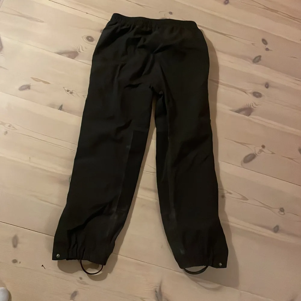 Säljer ett par svarta byxor från Helly Hansen i mycket bra skick. De är perfekta för utomhusaktiviteter med elastisk midja. Bra impregnering.. Jeans & Byxor.