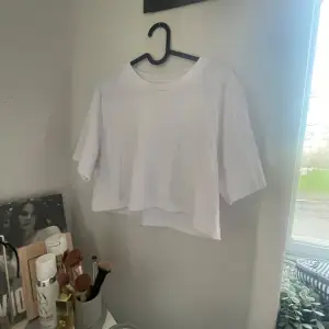 Säljer en vit croppad t-shirt med korta ärmar och rund hals. Perfekt för som en del av en lager-på-lager-look. Runt halsen finns det en foundation fläck, men som säkert går att tvätta bort!