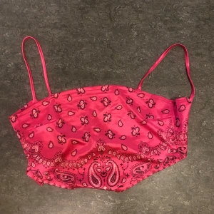 Rosa mönstrad topp - Säljer en superfin rosa topp med mönster. Toppen har smala axelband och är perfekt för sommaren. Materialet känns mjukt och bekvämt, och den har en snygg passform som framhäver figuren.