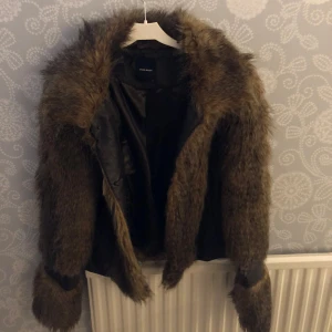 Brun pälsjacka från Vero Moda - Säljer en supercool brun pälsjacka från Zara. Den är perfekt för höst och vinter med sitt fluffiga material och stilrena design. Jackan har långa ärmar och en snygg krage som ger extra värme. Passar perfekt för både vardag och fest! 🐻