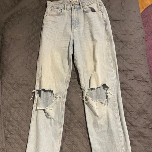 Ljusa jeans med slitningar - Säljer ett par ljusa jeans från G-Star Raw i storlek 36. De har en cool, sliten look med stora hål vid knäna och en klassisk femficksdesign. Perfekta för en avslappnad stil! Dragkedja och knapp framtill. Säljer dessa pga att de har tyvärr blivit försmå