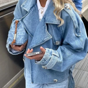 Meotine Jeansjacka  - Säljer en supercool ljusblå jeansjacka med bälte och stora knappar från Meotine. Jackan har en oversized passform och långa ärmar med justerbara manschetter. Perfekt för vår och höst, och funkar lika bra till vardags som till fest. Ett måste i garderoben för den som älskar denim! 💙 Nypris 3700kr 