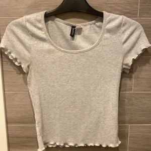 Grå ribbad topp  - Säljer en söt grå ribbad topp från H&M.  Superbekväm och lätt att matcha. Säljer pågrund av att jag inte använder längre. 