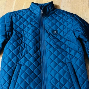 Polo jacka - Säljer en snygg blå quiltad jacka från U.S. Polo Assn. i storlek S. Jackan har en dragkedja framtill och är perfekt för höst och vår. Den har en stilren design med långa ärmar och två praktiska fickor. Aldrig använd.