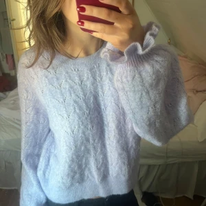 Ljuslila stickad tröja från & Other Stories - Superfin ljuslila stickad tröja från & Other Stories i storlek S. Den har ett snyggt mönster och långa ärmar med volangdetaljer vid ärmsluten. Perfekt för både höst och vinter, och den är så mysig att ha på sig! 💜