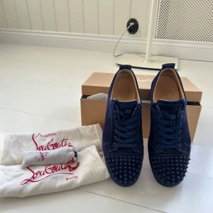 Blå sneakers från Christian Louboutin - Säljer ett par snygga blå sneakers från Christian Louboutin. Skorna är sparsamt använda och påsar, låda och ett par extra skosnören följer med. Skorna är självklart äkta! Hojta om du vill ha fler bilder! 
