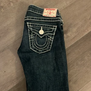 Mörkblå jeans med broderade fickor - Säljer ett par snygga true religion. De har en tight passform och låg midja, Jeansen är i bra skick. Och ändats använda ett få tal gånger. Perfekt för höst och vår!