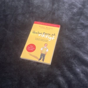 Himlen finns på riktigt - Boken 'Himlen finns på riktigt' av Todd Burpo handlar om en pojkes upplevelse av himlen. Omslaget är gult med en bild av en pojke i mitten och röd text högst upp. Perfekt för den som är intresserad av andliga berättelser och livets stora frågor.