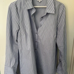 Ljusblå skjorta - Ljusblå skjorta (Minou) med vita ränder från Bubbelroom i strl 40. Aldrig använd.