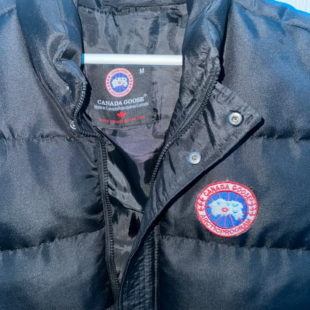 Säljer denna fina canada goose västen i storlek M, använd 1-2 gånger men skicket är fortfarande väldigt bra, en knapp saknas på sista bilden därför kan priset diskuteras vid snabb affär!. Jackor.