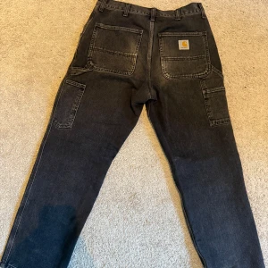 Carhartt workwear jeans  - Hej, jag säljer ett par riktigt schyssta par carhartt single kneepant jeans i färgen svart/grå, stone washed, skick 9/10 inga defekter och inga tydliga tecken på användning! Hör av er vid minsta lilla! Pris är ej hugget i sten
