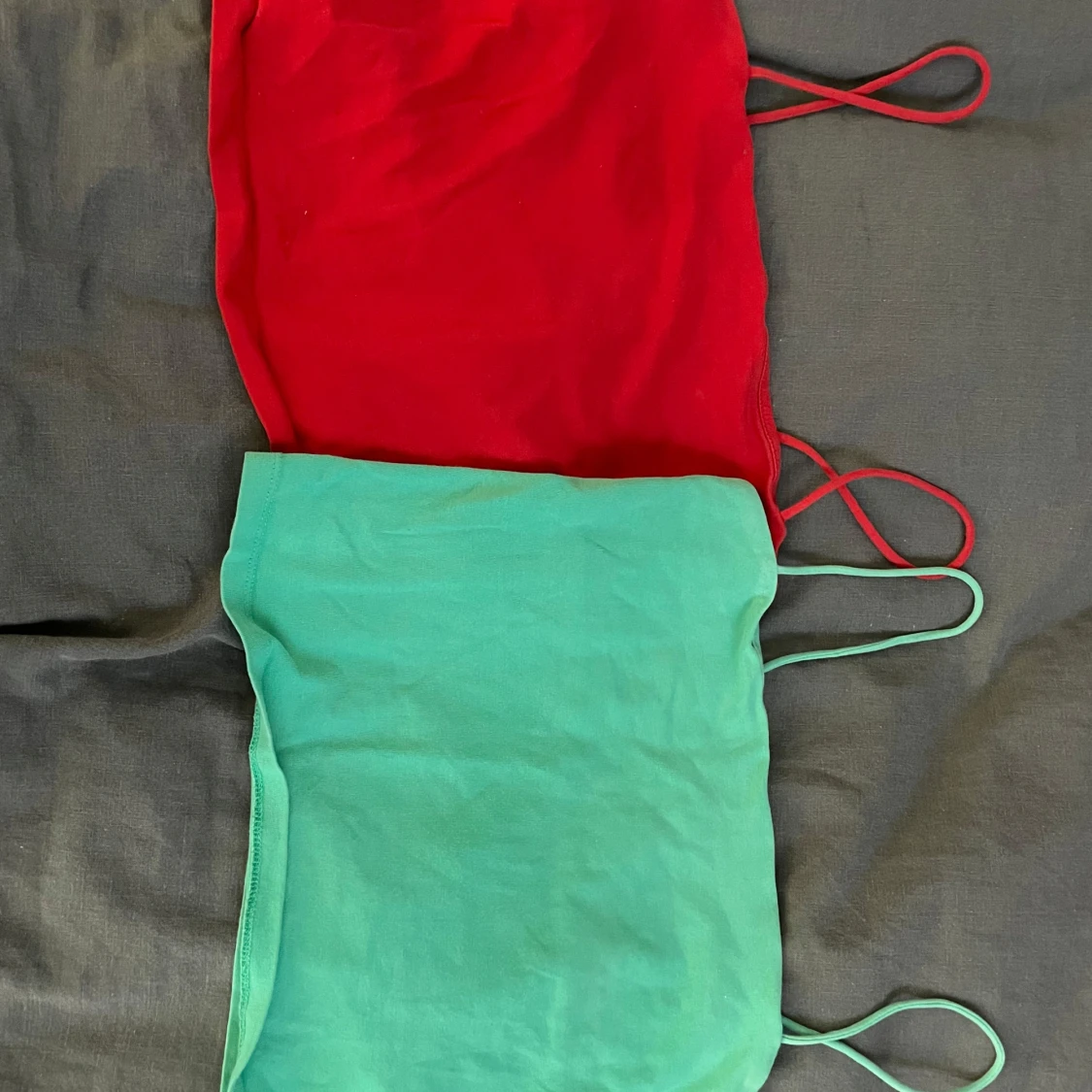 Två tubtoppar i rött och grönt