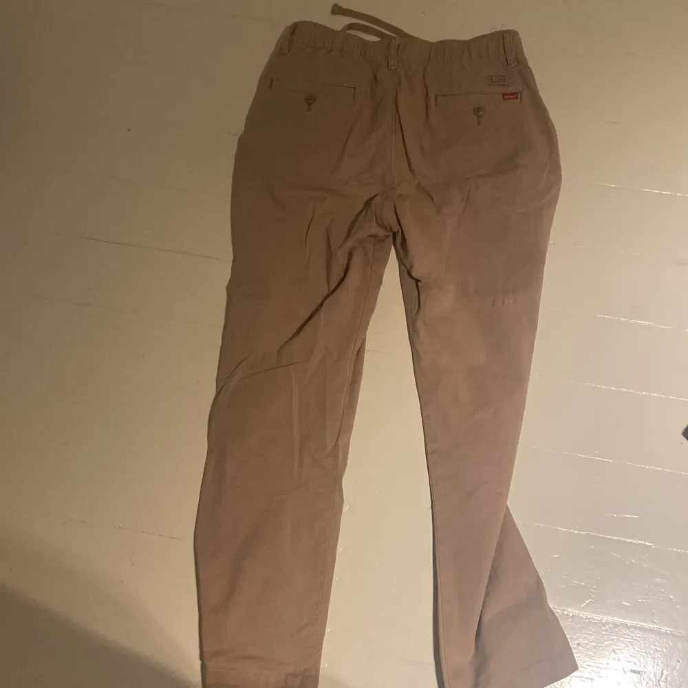 Beige chinos från Levis med storlek XS, 3 år gamla men funkar fint fortfarande. Går både att knyta och ha skärp. Jeans & Byxor.