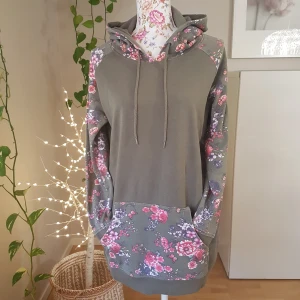 Olivgrön/blommig färgblock hoodie - Lång, mysig hoodie i fint begagnat skick. Lös liten söm på fickan & blivit lite noppig, men lätt att ta bort med maskin/rakhyvel. ~ STOR rensning i min shop ~ Välj 5 för 100kr oavsett pris, skicka medd/lämna som prisförslag (gäller där det står) ~