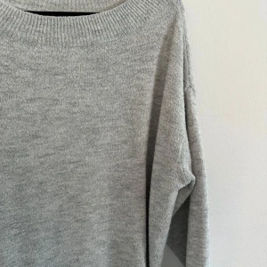 Grå stickad tröja - Mysig och enkel grå stickad tröja perfekt för kyliga dagar. Den har en avslappnad passform med långa ärmar och en rund halsringning. Perfekt att matcha med jeans eller leggings för en casual look. Tvättad några gånger därav nopprig.
