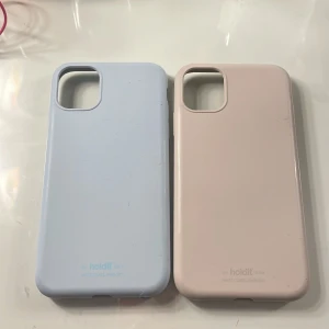Silikon iPhone 11 skal - Detta skalen är ej till andvöndning längre, båda är iPhone 11 skal och i färgen blå och beige. Jag säljer båda för 90kr, men om ni bara vill ha en kostar det 45kr. Några få sprickor längst ner, men går fortfarande att and vända helt normalt.❤️👍🤍