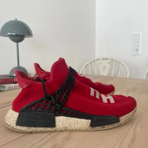 Human race x Pharell Williams  - Röda Human race x Pharell Williams. Köptes 2020 för 3800 kr på drop. Dem är lite slitna sedan dess. Inga större märken eller skador endast det som visas på bilderna.