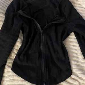 Svart top med dragbar dragkjedja  - Tröja med dragkjedja så du själv kan välja om du vill ha stängt eller mer uringat 