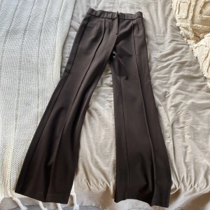Dressad kostymbyxa  - Dressad mörkbrun kostymbyxa från chiquelle. Storlek 38, något mindre i storleken. Aldrig använda. Ett litet hål under gylfen. 