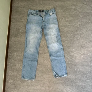 Ljusblå jeans från Karve - Säljer ett par ljusblå jeans från Karve. De har en klassisk femficksdesign och är i en straight fit. Jeansen har en sliten look med fransiga benslut, vilket ger dem en cool och avslappnad stil. Perfekta för vardagsbruk!