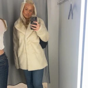 Beige päls kappa - Säljer min mysiga vinter kappa som är köpt förra året. Den går ner till rumpan och håller värme väldigt bra