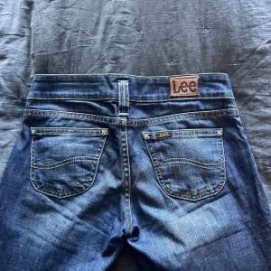 Lågmidjade bootcut vintage Lee jeans 💕 - Hej! Säljer nu dessa assssnygga lågmidjade lee jeansen. Köpte second hand men passade inte mig tyvärr! Sista bilden är förra ägarens bild.   Midjemåttet rakt över: 37 cm Innerbenslängden: 83 cm De är bootcut💕💕