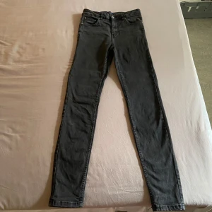 Svarta skinny jeans från NLY - Säljer ett par svarta skinny jeans från NLY / NELLY. De är högmidjade och har en klassisk femficksdesign med dragkedja och knapp framtill. Perfekta för både vardag och fest! Otroligt sköna och snygga. SUPER STRETCH 