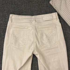 Jeans - Snygga vita bootcut jeans med aaas snygga detaljer på bakfickorna! Säljer då de blivit för små🥲