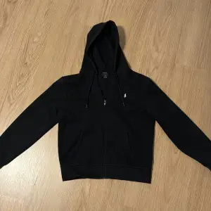 Säljer nu denna svarta polo ralph lauren full zip hoodien som är i storlek M. Den är i 8/10 skick och endast använt några gånger. Tröjans org pris är 1999. Kvitto ingår såklart. Skriv om ni undrar något!