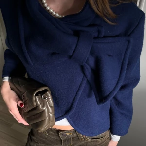 Rosett kappa - Blå lite kortare kappa i ull med en rosett som detalj. Vet tyvärr inte märket efter som det är min mammas gamla och inget står i men skulle säga att det är en XS-M beroende på hur man vill att den ska sitta. Perfekt modell och blå färg💙