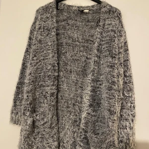 Kofta grå - Grå fluffig kofta från H&M storlek S. Mjuk och fin i materialet. Bara använd ett fåtal gånger