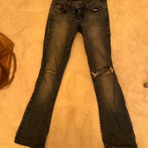 Bootcut Jeans - Bootcut jeans från Jaggy. Hade förut hål i skrevet men är ihopsydda.  Storlek: 42 (känns som 36/S) Innerbenslängd: 78 cm