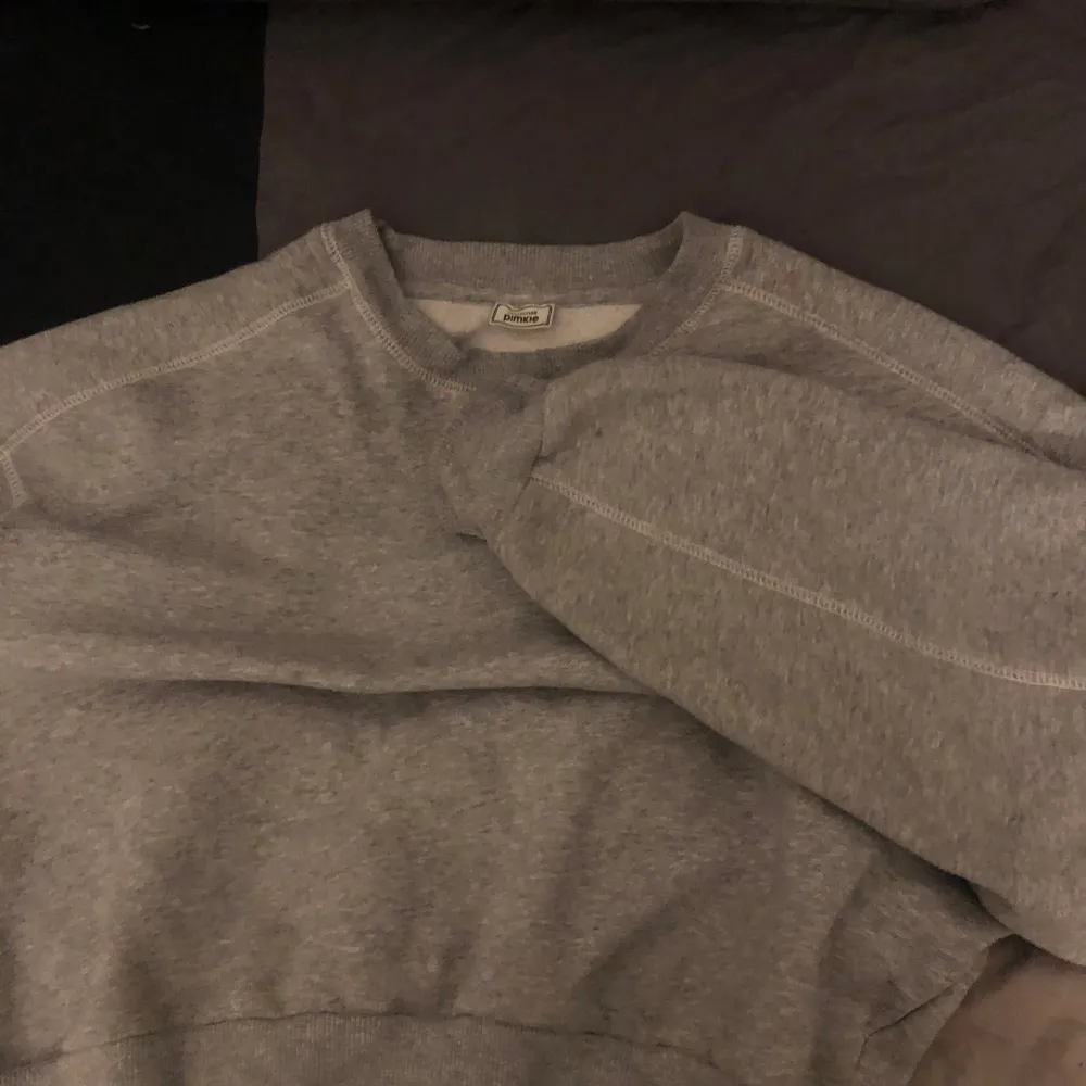 Säljer en supermysig grå sweatshirt från Pimkie. Perfekt för chilliga dagar eller när du bara vill ha något bekvämt. Den har långa ärmar och en klassisk rund halsringning. Materialet känns mjukt och skönt mot huden💕💕. Tröjor & Koftor.