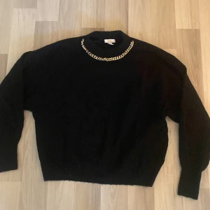 Stickad tröja  - Fin stickad tröja som har en kedja vid halsen som dekoration 