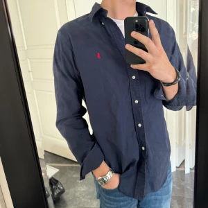 Ralph lauren skjorta🌟 - Skitsnygg och eftertraktad ralph lauren skjorta i marinblå färg. Skjortan är i bra skick men lite skrynlig! Hör av er för mer info eller diskustion om pris! Byten kan vara intressant!