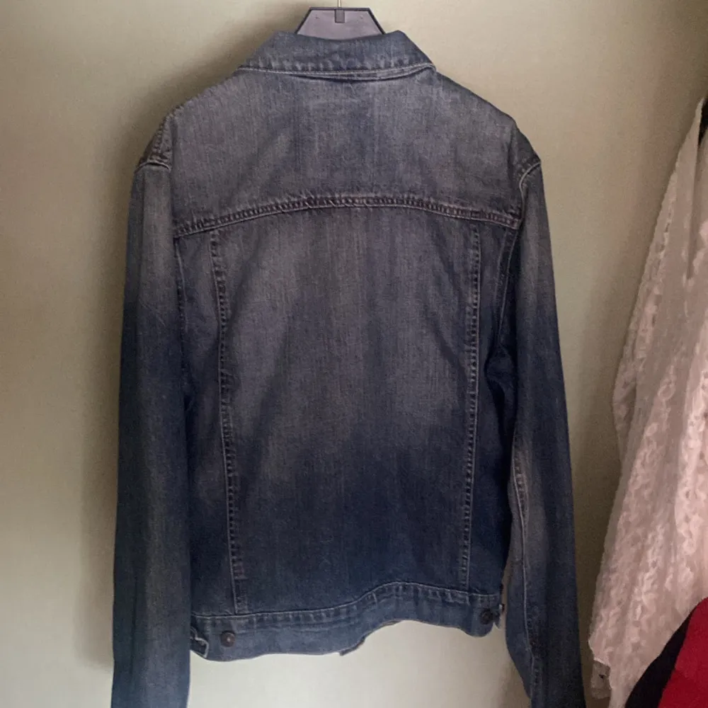 Säljer en snygg jeansjacka från L.O.G.G. av H&M. Den är i klassisk blå denim med knappar framtill och två bröstfickor med lock. Jackan har en normal passform och är perfekt för vår och höst. Den är långärmad och i nyskick. Nypris 349. Jackor.