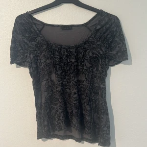 Svart mönstrad topp - Säljer en snygg svart topp med ett detaljerat mönster. Toppen har korta ärmar och en rund halsringning. Fin deltaljering se bild 3. Använd fåtal gånger!🩷 