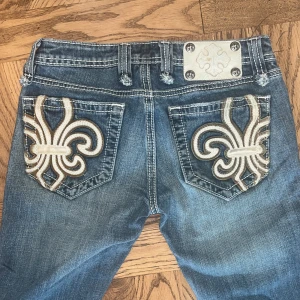 Blå jeans från Miss Me - Säljer ett par snygga blå jeans från Miss Me. De har en cool broderad design på bakfickorna. byxorna är bootcut i storlek 25. Inner- ben längden är ca 80 cm. Sälger på grund av att det är för små. Köpt secondhand. 