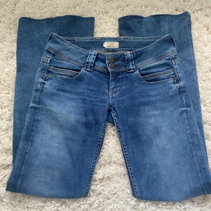 Blå jeans från Pepe Jeans - Säljer ett par snygga blå jeans från Pepe Jeans. De har en låg midja och en bootcut-stil som ger en avslappnad look. Jeansen är i klassisk blå demin.            jag har sytt ut dom till bootcut som man kan se på sista bilden men det är inget som syns på 💓                    mått: midja 37/38 cm längd 80 cm 