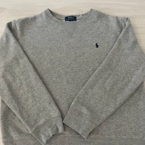 Grå tröja från Ralph Lauren - säljer nu min Ralph Lauren tröja på grund av att den är liten, den har bra skick och är Large i barnstorlek så den passar om du är 150-160cm lång kontakta för mer info och bilder