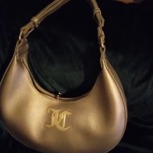 Yk2 handväska  - Söt guldig handväska ifrån juicy couture ,00tal, fint skick inga slitage utvändigt. Finns lite slitage inuti. 