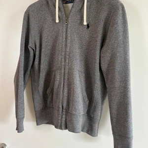 Ralph Lauren Hoodie - Grå Ralph Lauren hoodie som är sjukt skön och stilren. Finns även att par mjukisbyxor som set.