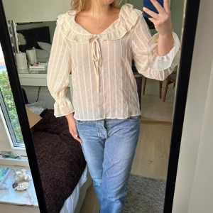 Fin randig blus - Superfin beige randig blus med krage och volanger och rosett