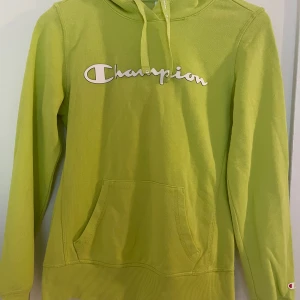 Hoodie från Champion - En jättefin hoodie med flckor på magen. Enda minuset är de små fläckarna som finns på mudden av ena ärmslutet. Det kan man se på bild nr 3. Fast det är inte stora som syns på bilden. Storlek S. 