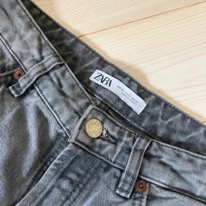 Lågmidjade grå jeans - Jättesnygga lowrise jeans från Zara! Mina favorit jeans som jag tyvärr har växt ur. Storlek 36, har en liten blekt fläck(se bild)