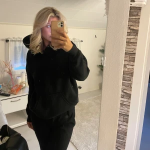 Svart hoodie - Säljer en svart hoodie som är supermysig och perfekt för kyliga dagar. Den har en klassisk design med en stor ficka fram och en bekväm huva. Passar perfekt för en avslappnad stil eller när du bara vill mysa hemma.