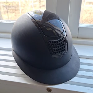 Ridhjälm  - En snygg Ridhjälm med Mips system från Höösk. Endast använd 5 gånger max, har ändast små repor på baksidan, kan skicka bilder om man vill på det. Den är skimmrig högst upp på huvudet. Nypris 1799kr. Aldrig avramlad med. Storlek 56-58/M. Säljs för att det var för liten. 